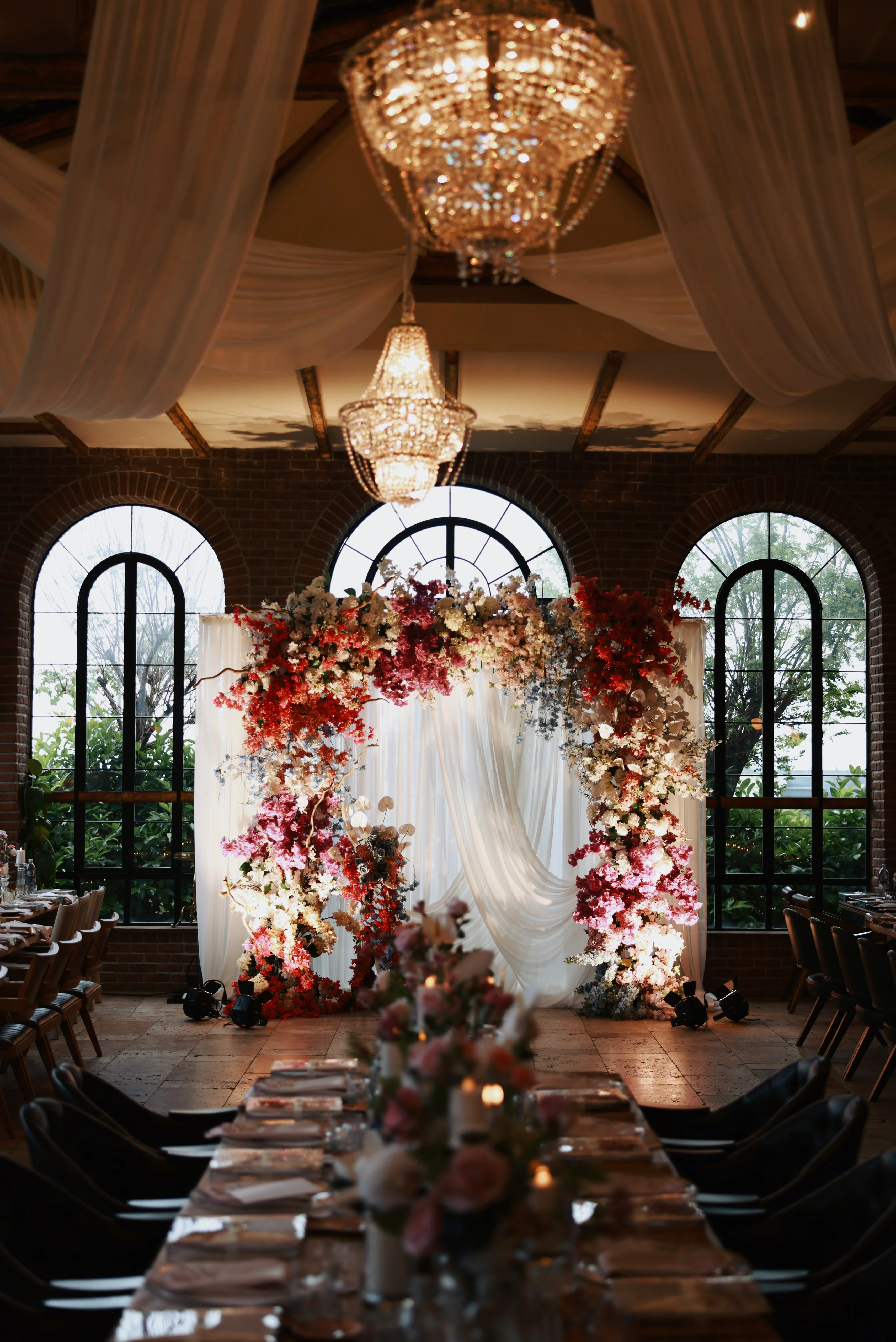 Ceremony axis between long tables leading to the floral arch