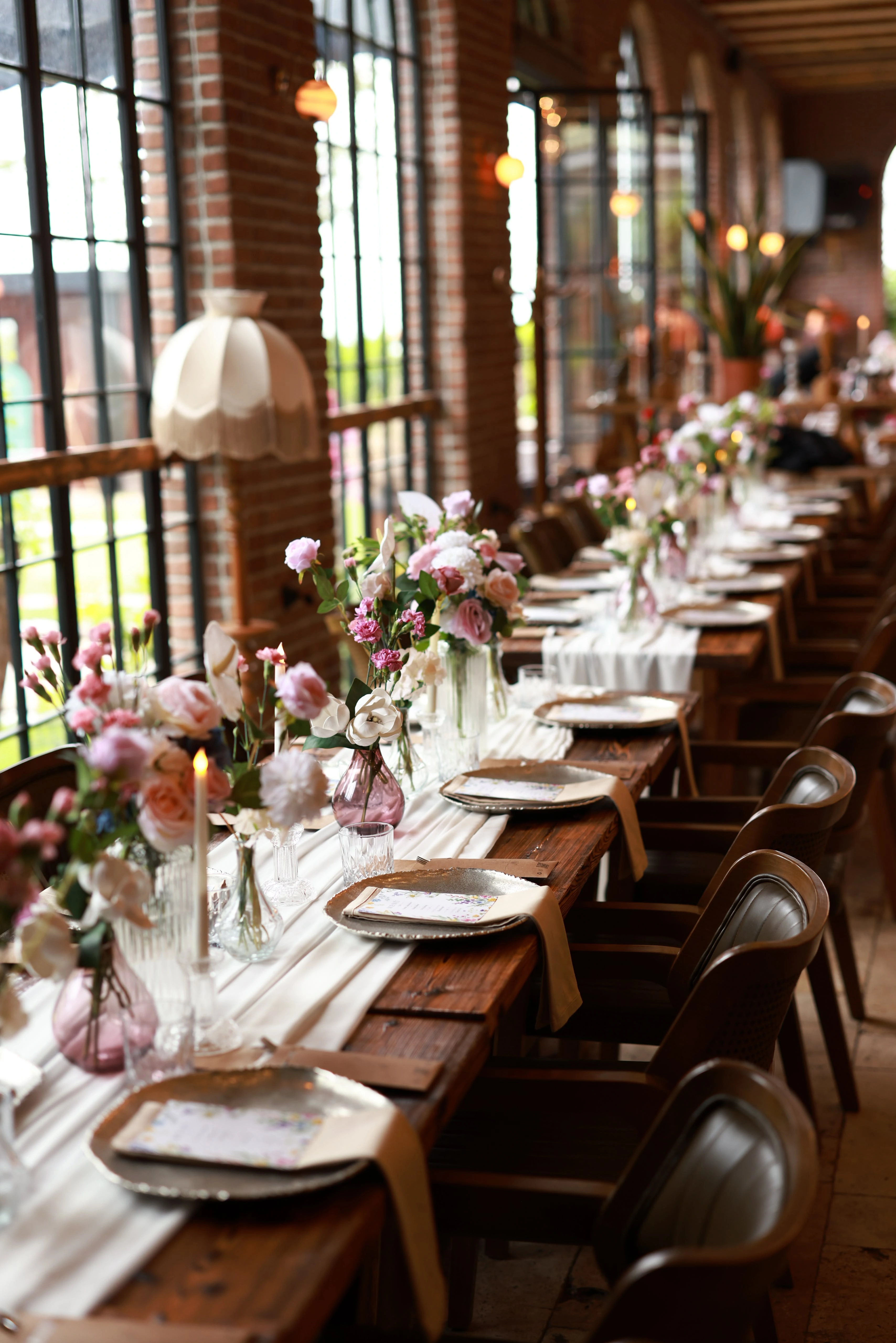 Perspective of a long banquet table stretching into the distance in window daylight