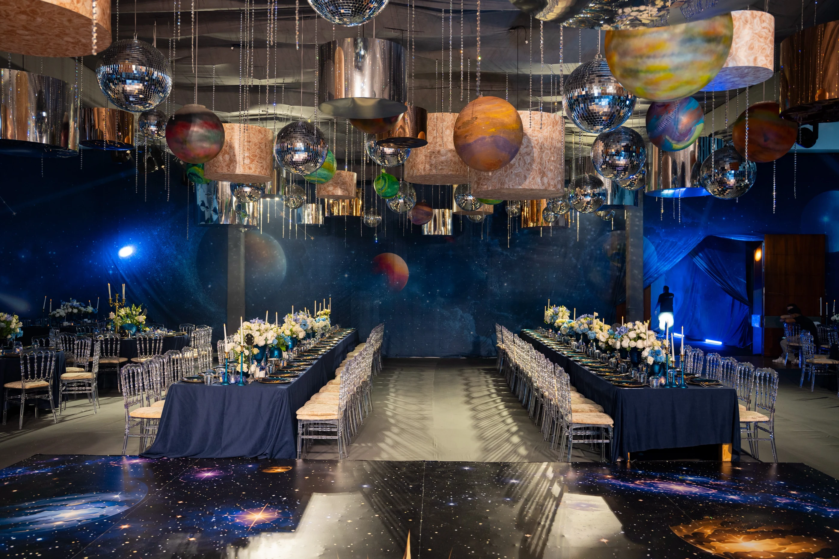 Cosmic celebration hall with suspended planets and long tables