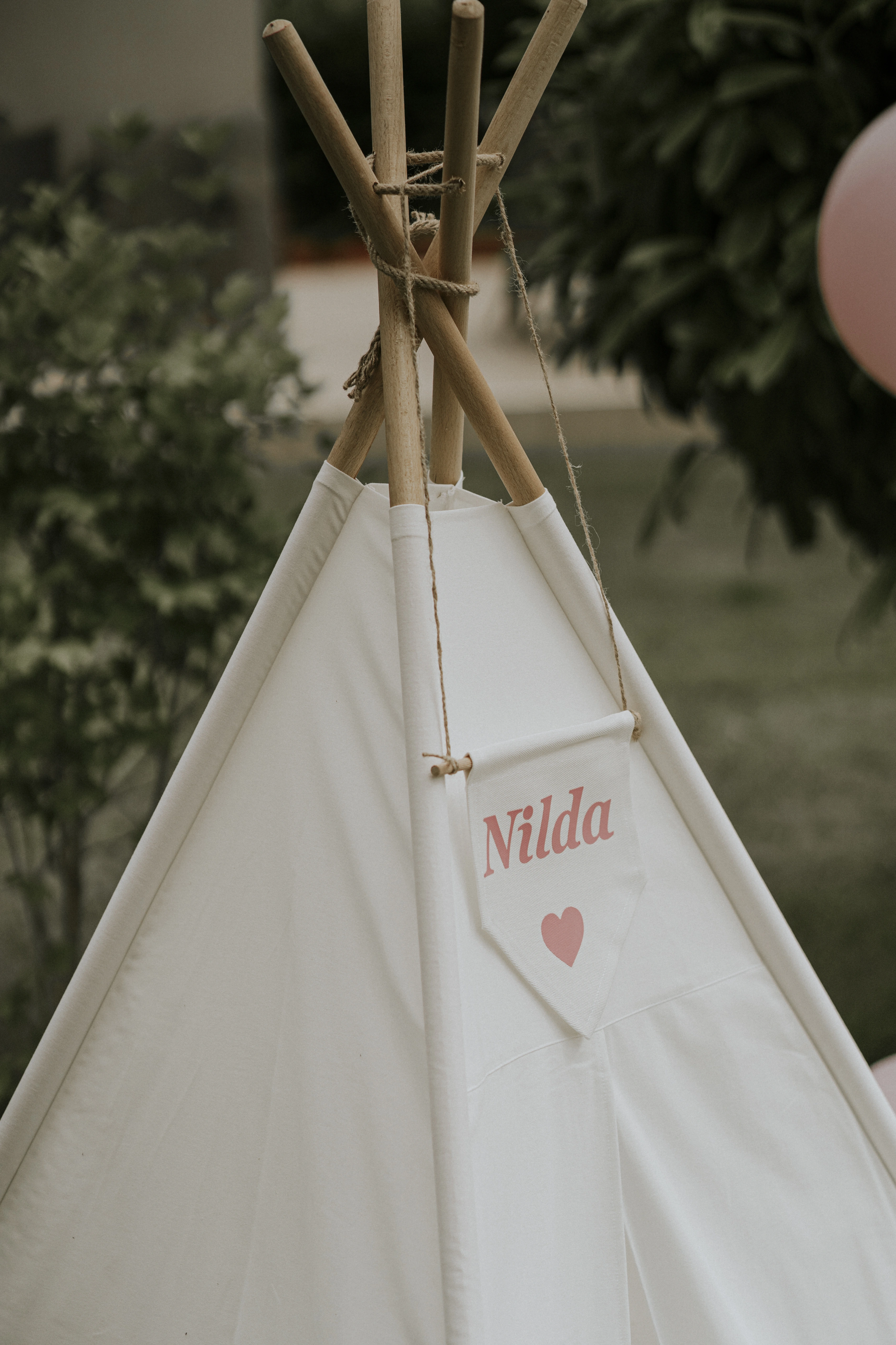 Close view of a white children's teepee with a name pennant