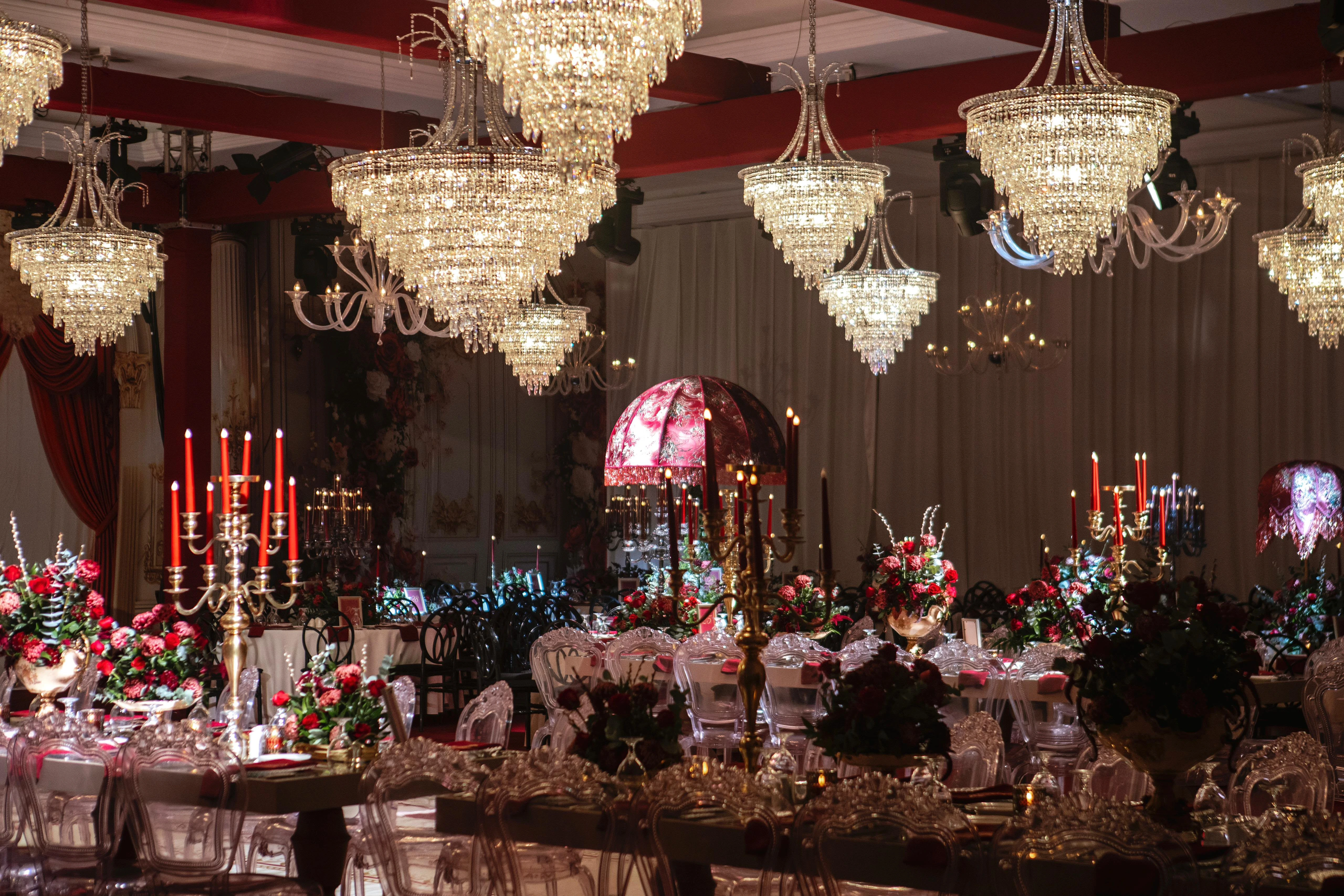 Wide view of the henna night hall with crystal chandeliers and rose-toned flowers