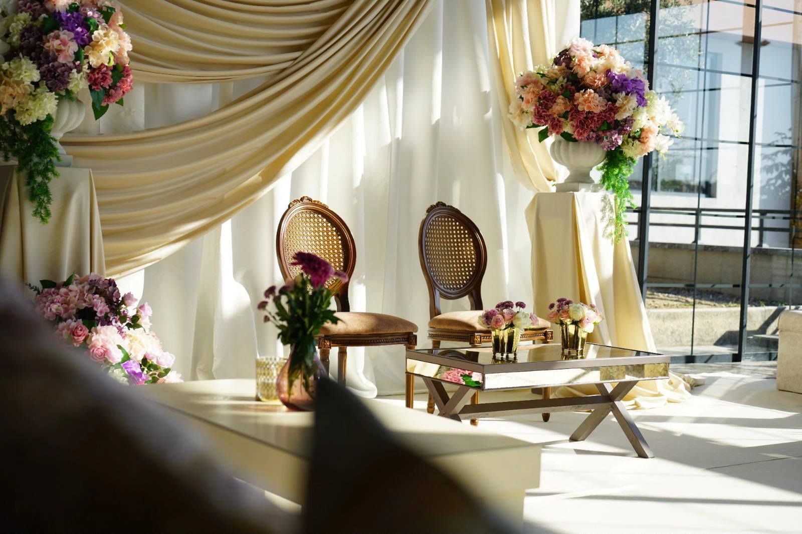 Engagement setting with ivory drapes and flowers, view 1