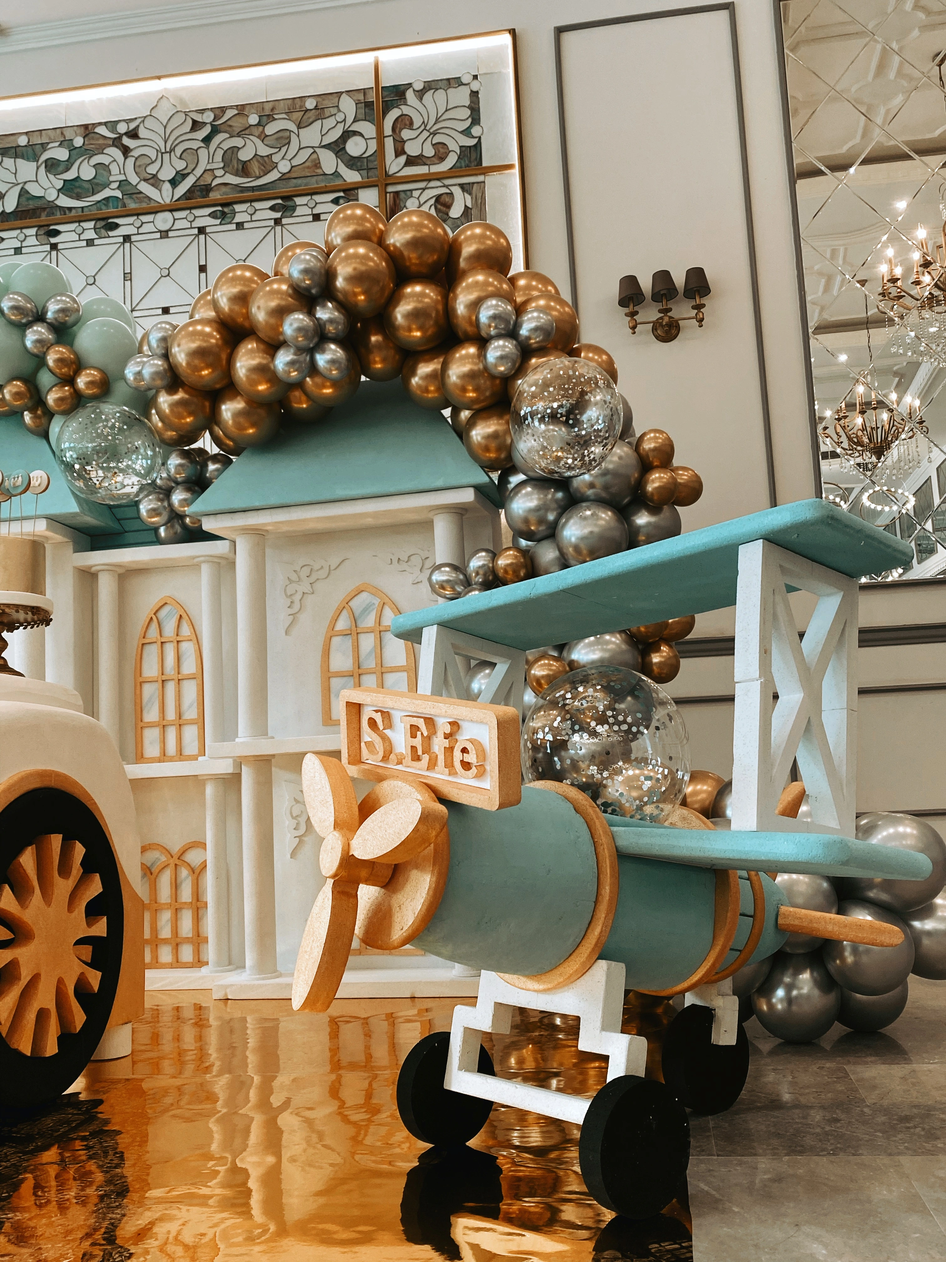 Mint ve gümüş balon kemeri önünde pervaneli vintage uçak ve otomobil figürleri