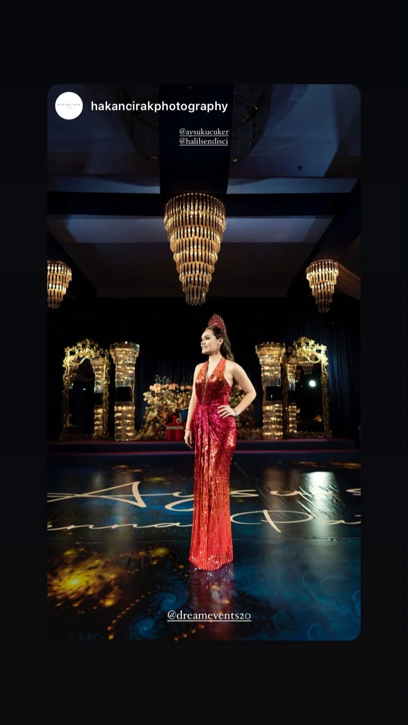 Henna night guest in a red dress in front of crystal lights