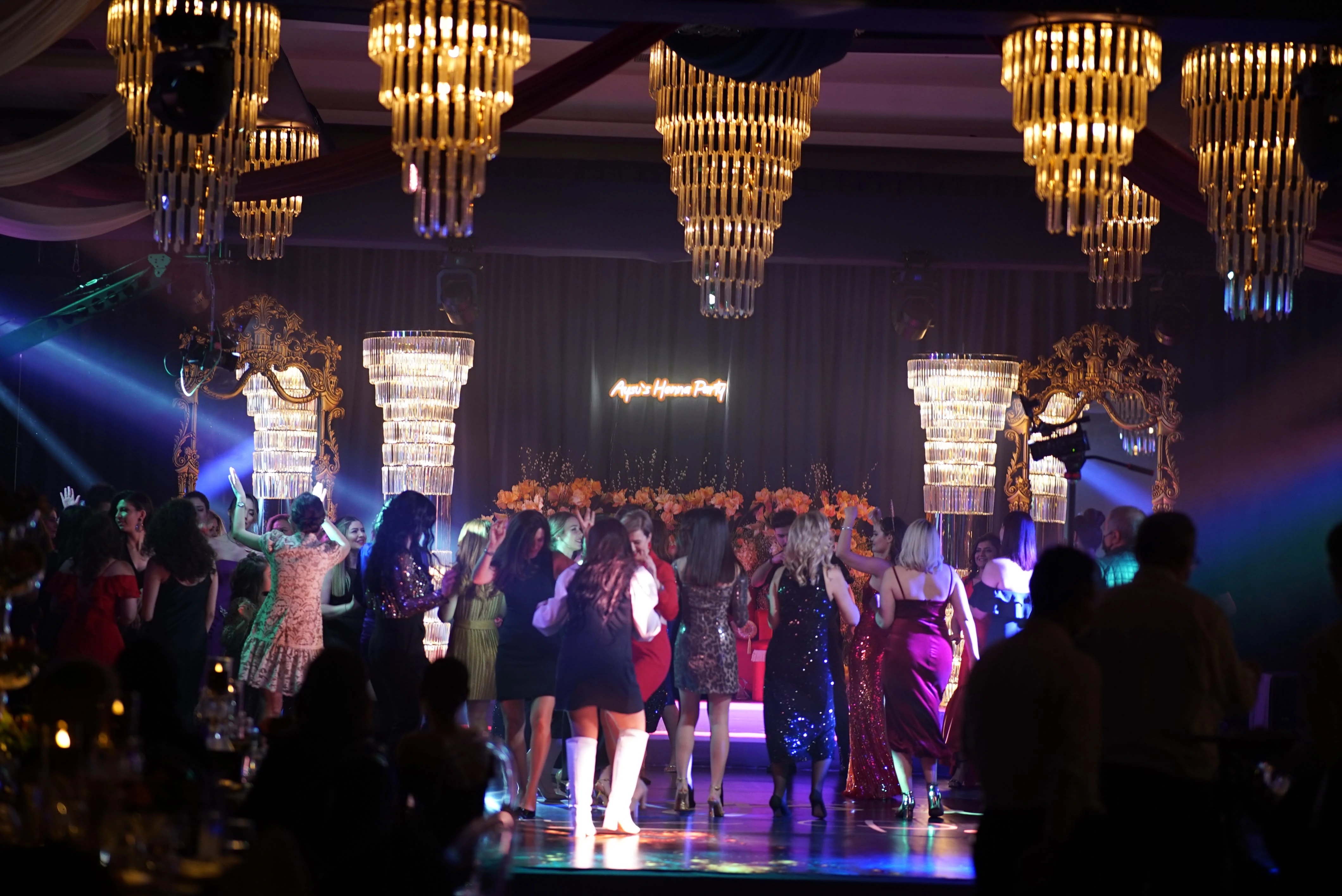 Henna night guests dancing beneath crystal chandeliers