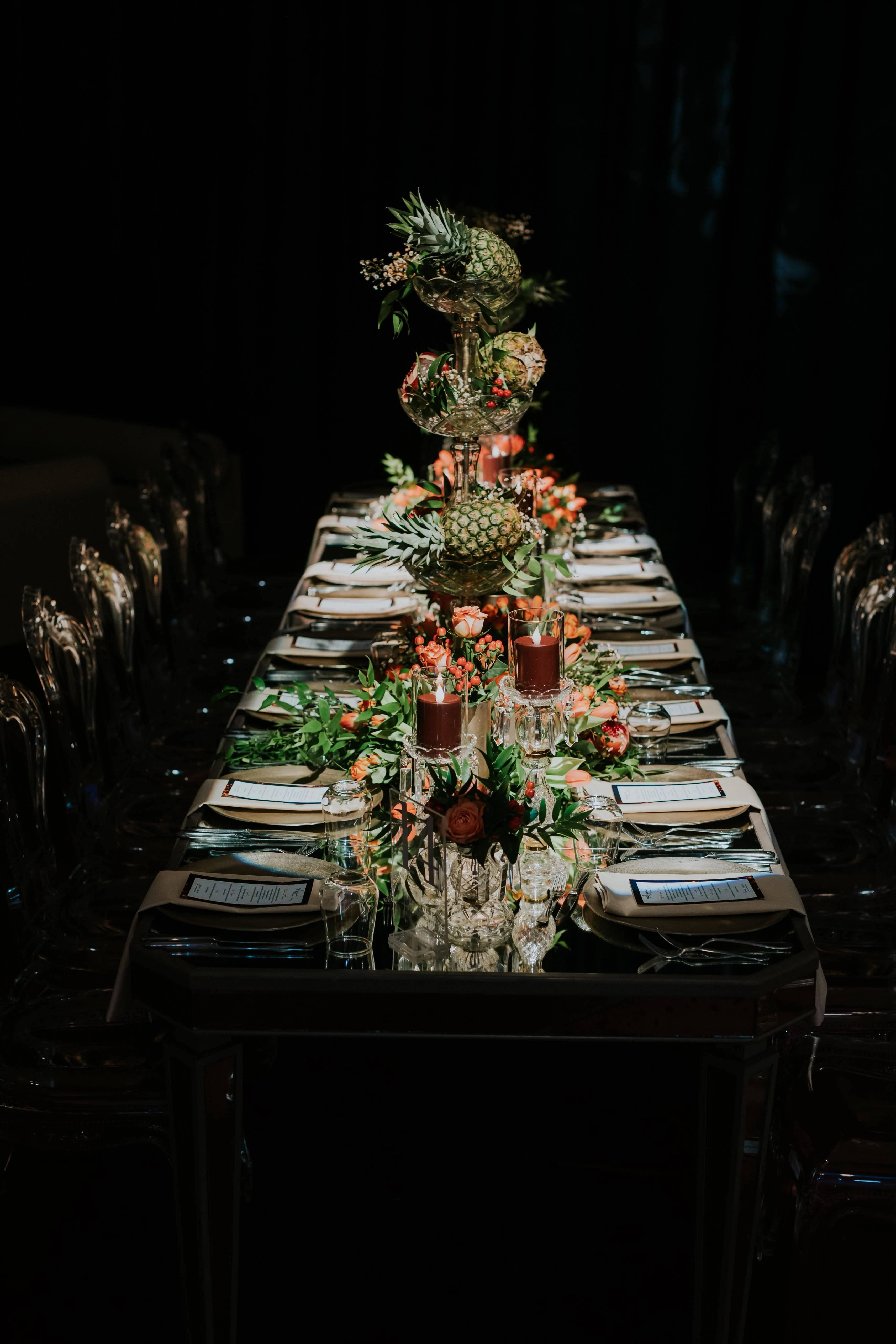 Table setting with citrus and flowers on a dark table