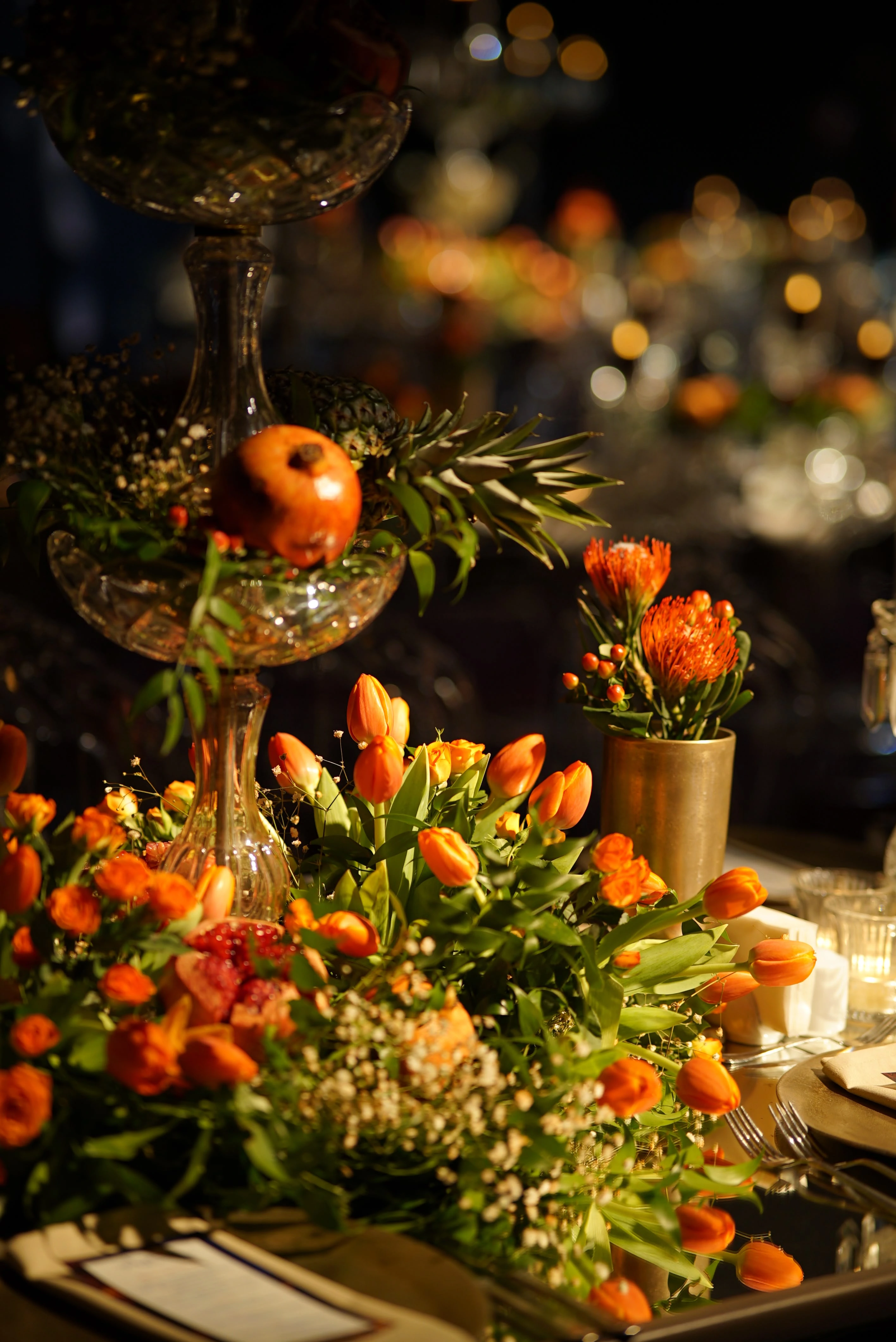 Table detail layered with pomegranates and orange flowers