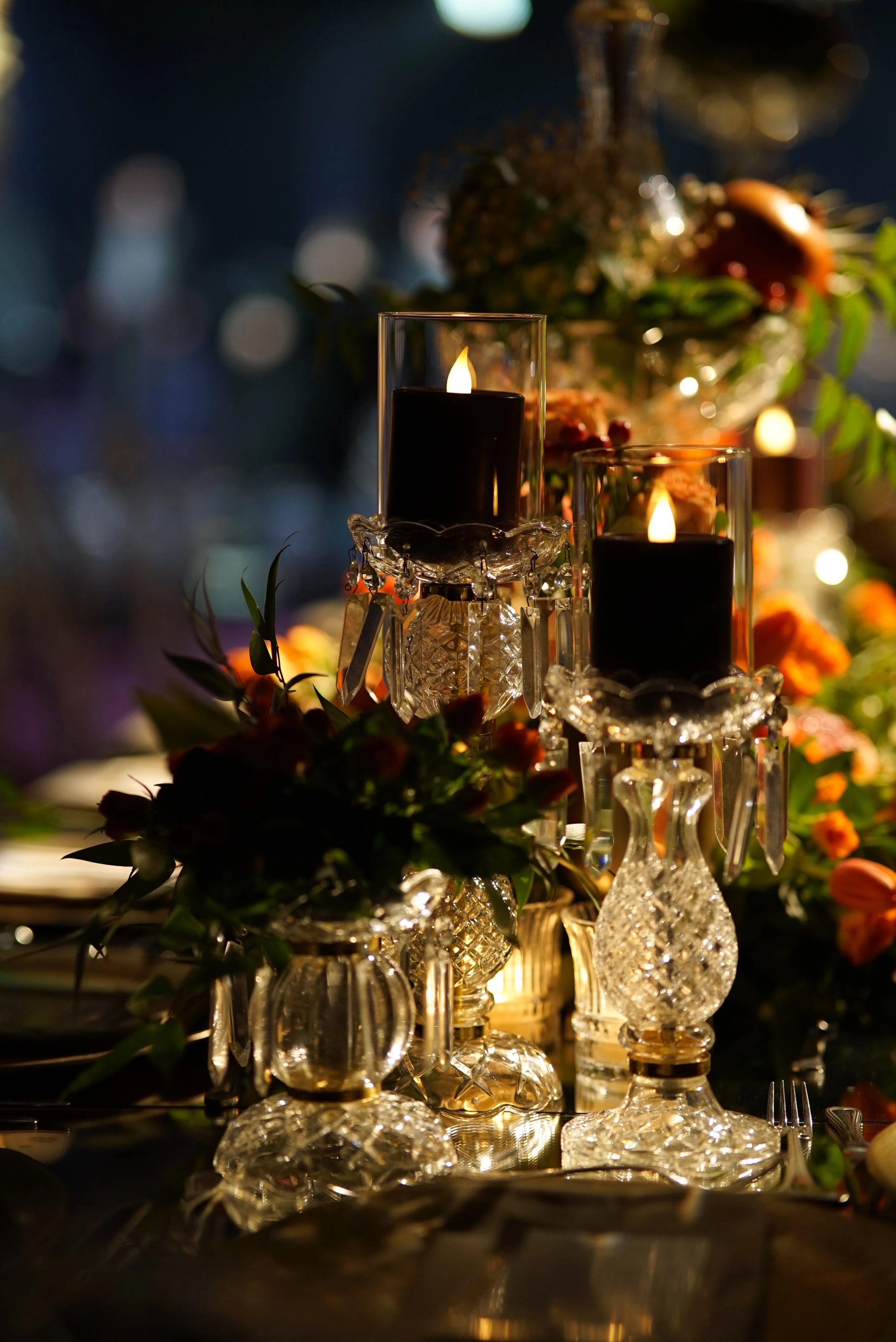 Glass, candles and citrus details on a dark table