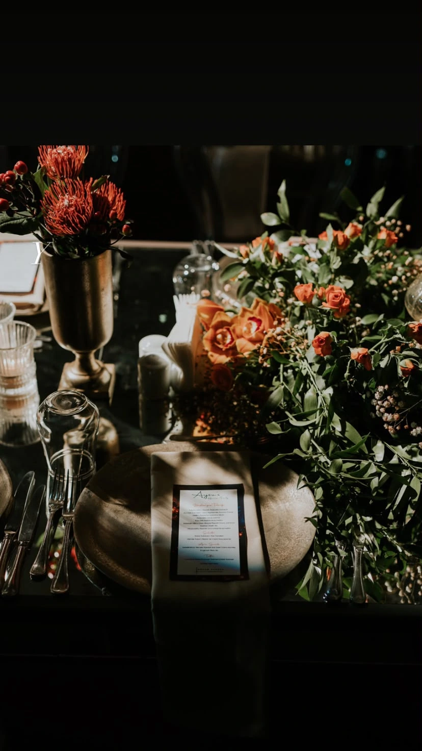 Guest table surrounded by citrus-toned flowers