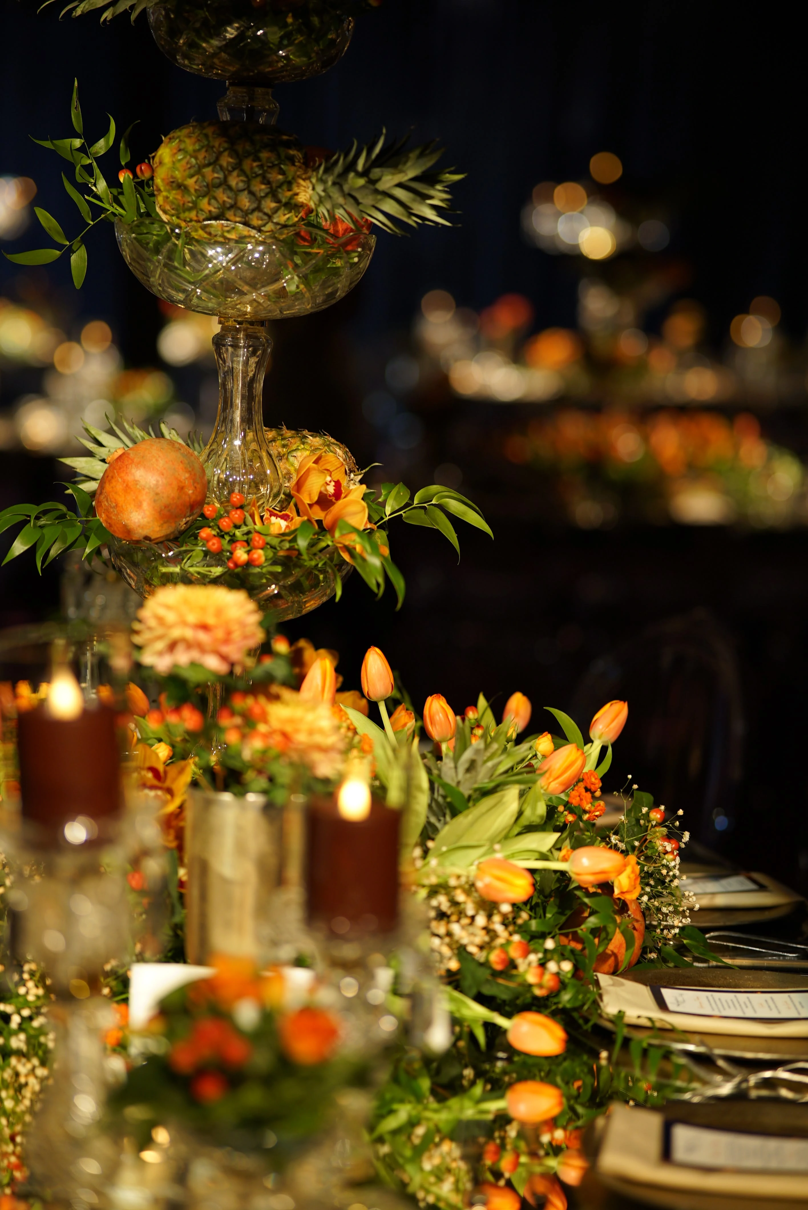 Perspective of a table with orange flowers on a dark floor