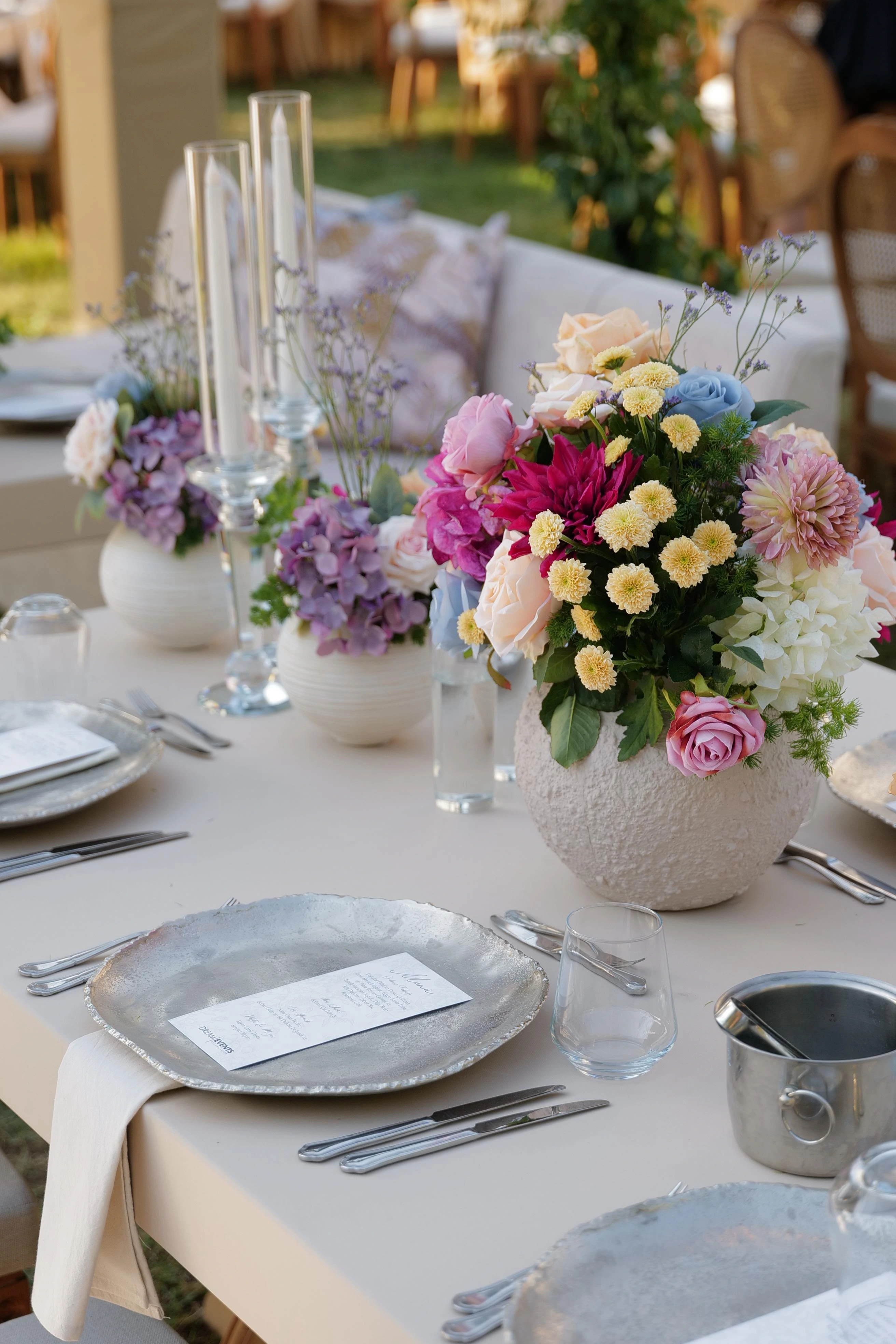 Garden engagement with crystal chandeliers, pastel flowers and wooden chairs, view 3