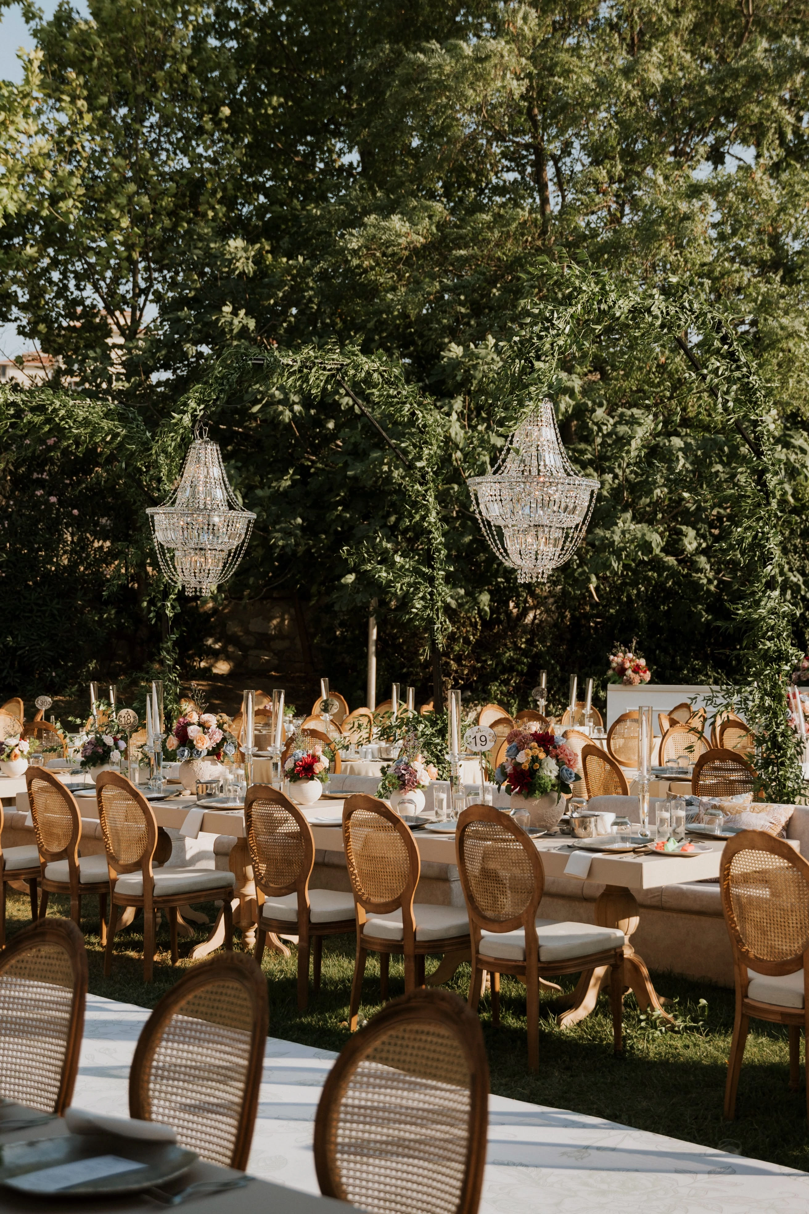 Garden engagement with crystal chandeliers, pastel flowers and wooden chairs, view 8