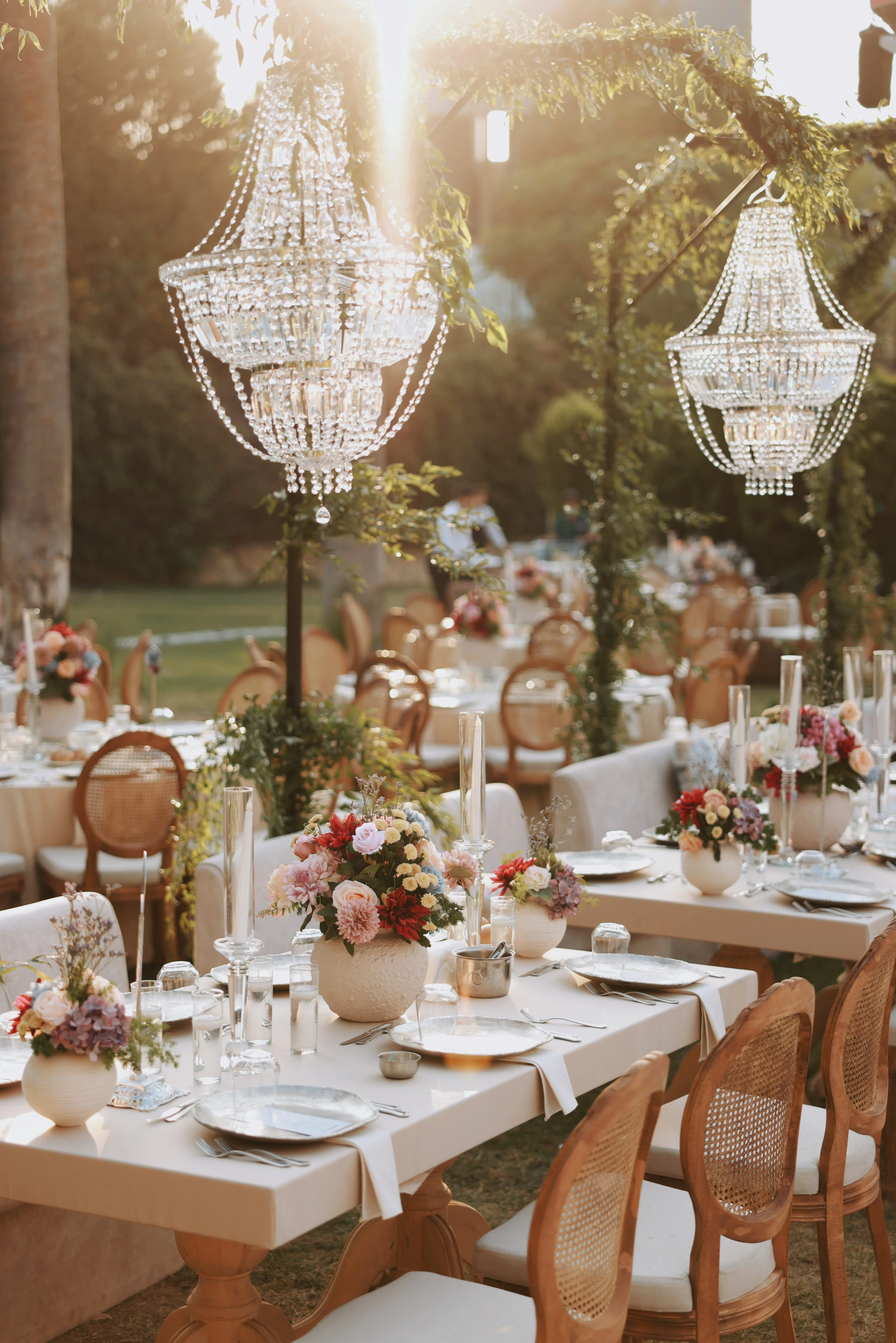 Garden engagement with crystal chandeliers, pastel flowers and wooden chairs, view 15