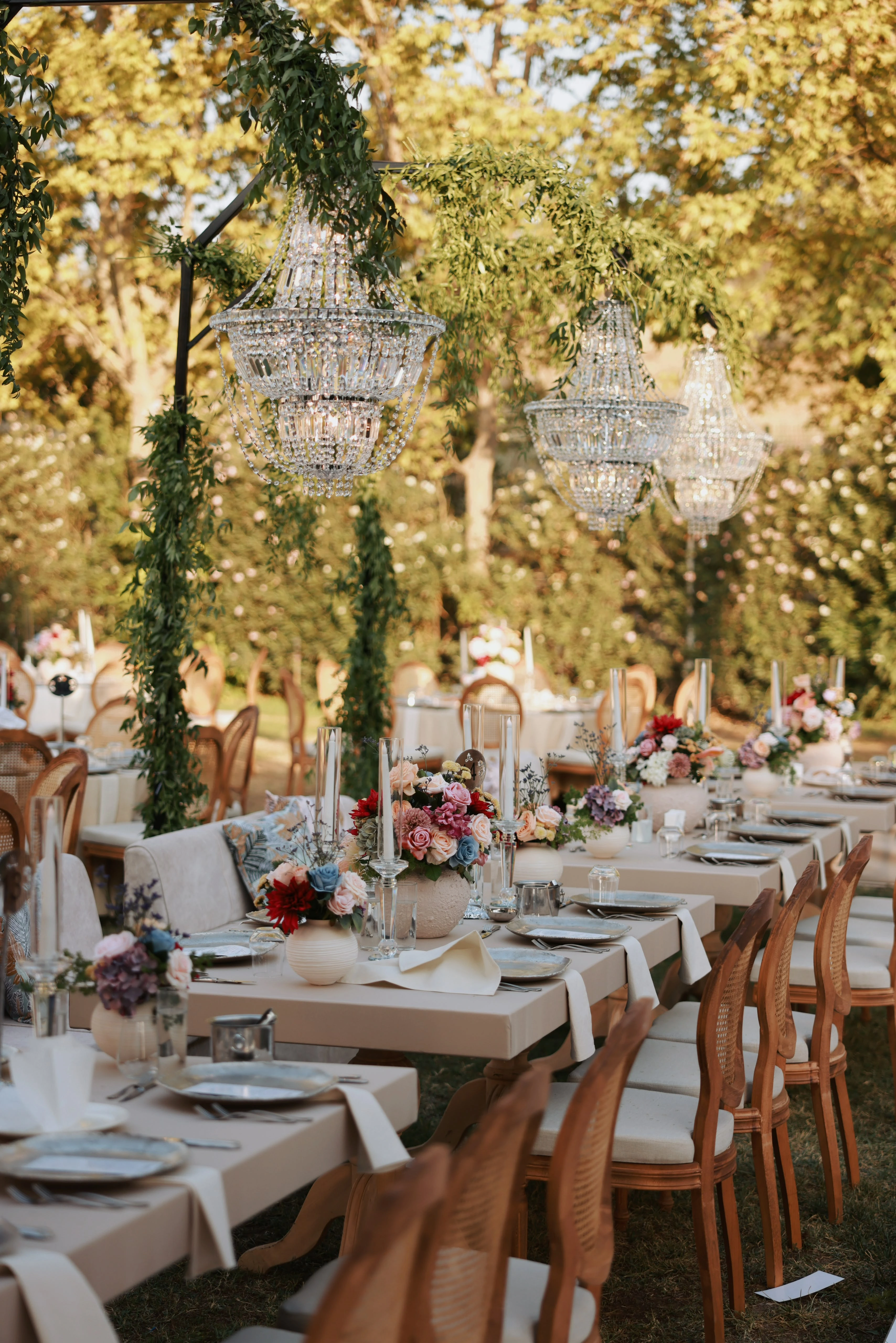 Garden engagement with crystal chandeliers, pastel flowers and wooden chairs, view 21