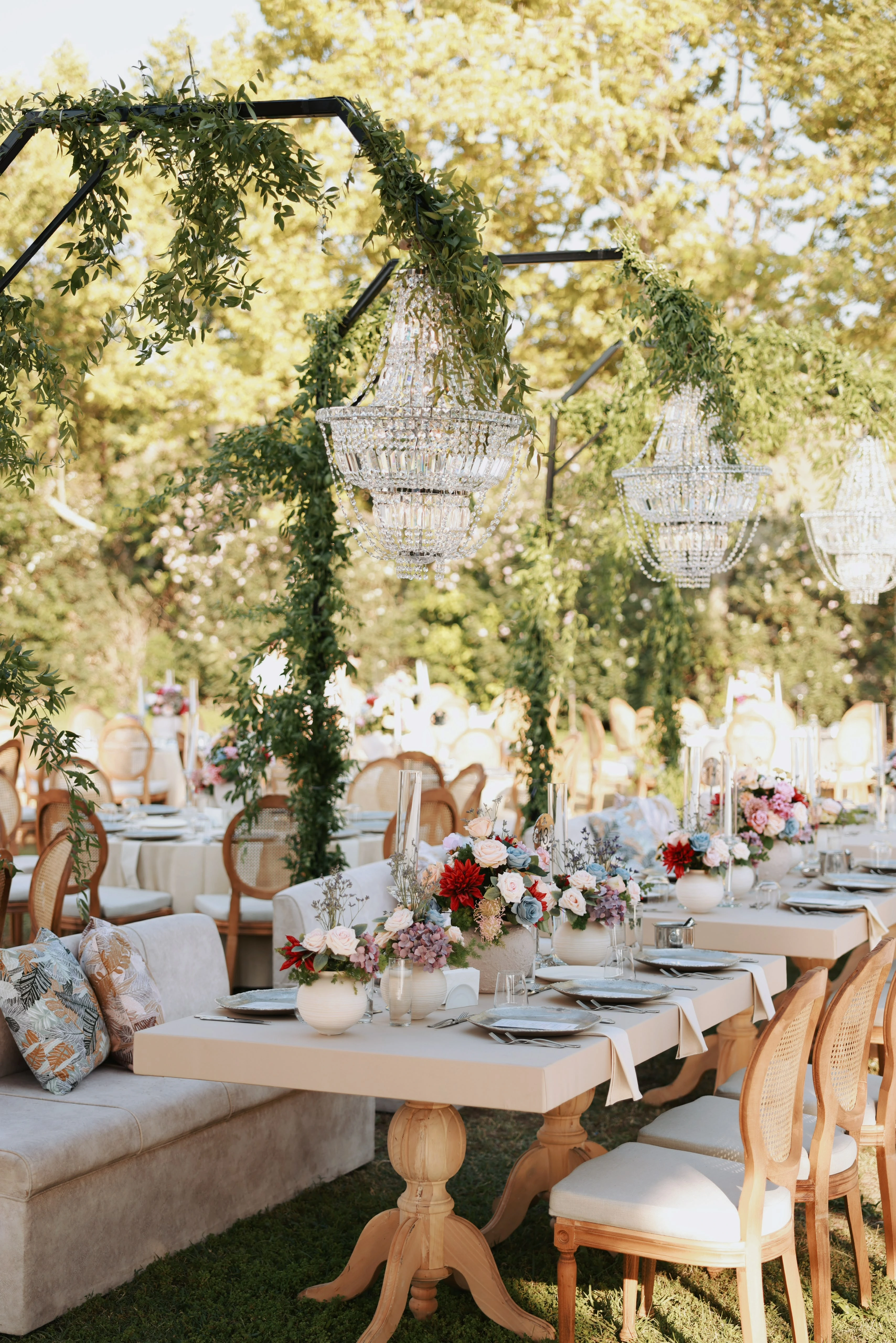 Garden engagement with crystal chandeliers, pastel flowers and wooden chairs, view 22