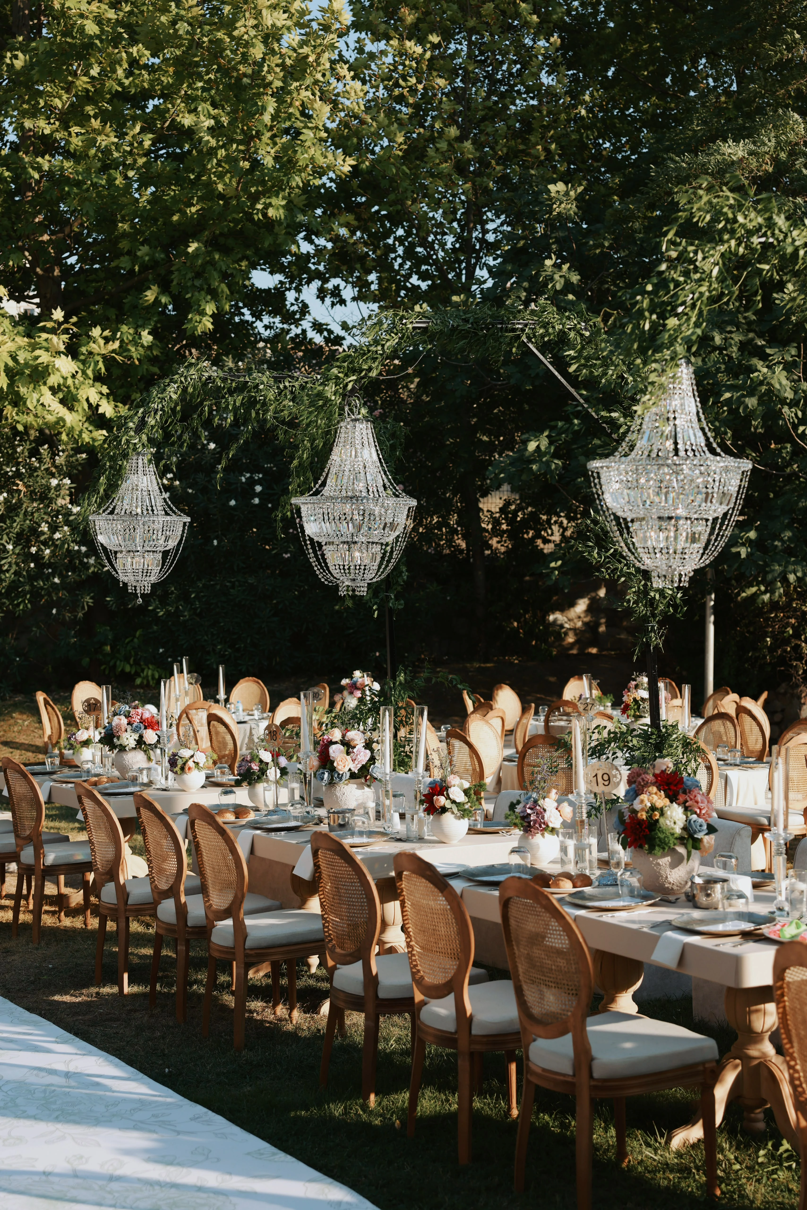 Garden engagement with crystal chandeliers, pastel flowers and wooden chairs, view 24