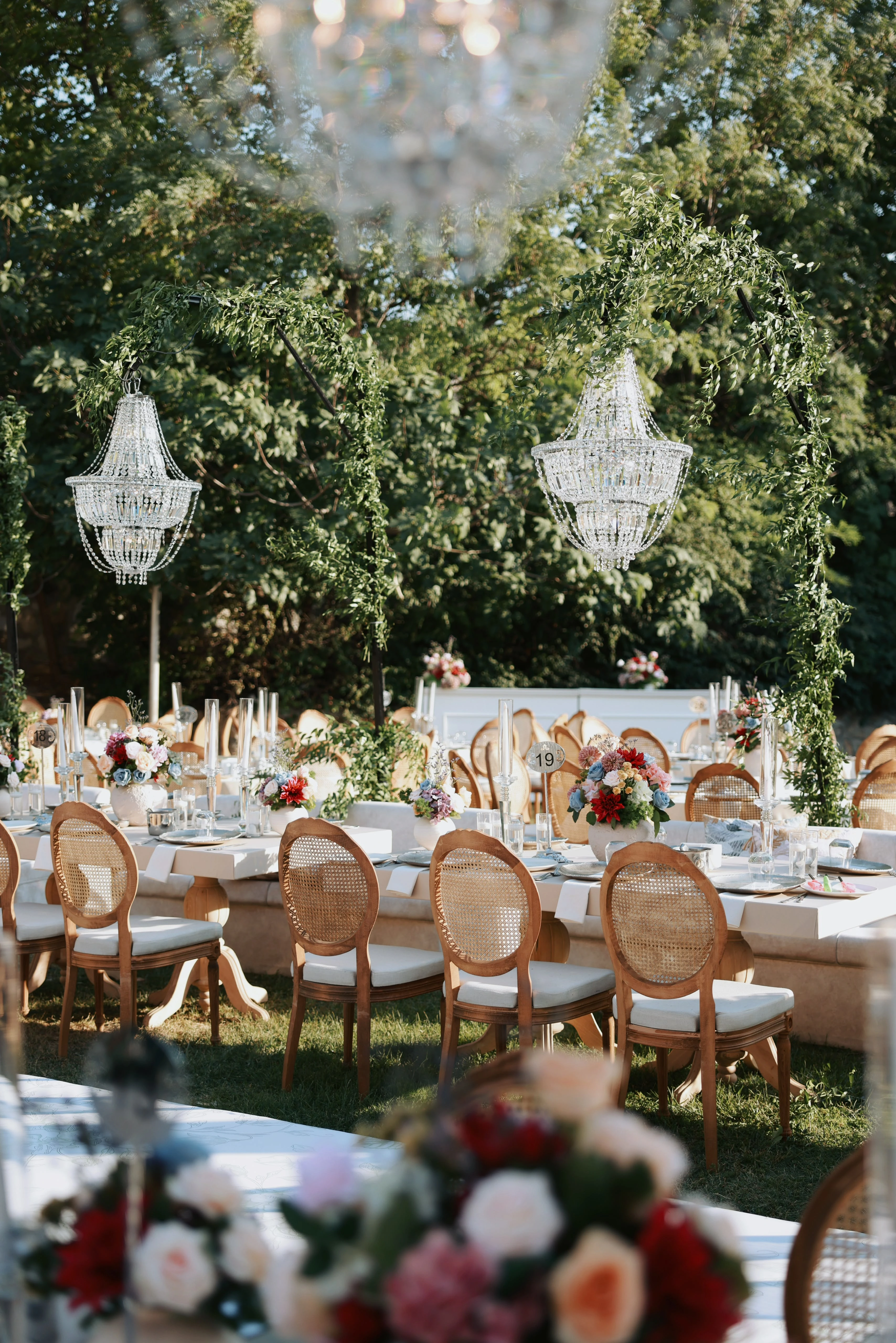 Garden engagement with crystal chandeliers, pastel flowers and wooden chairs, view 28
