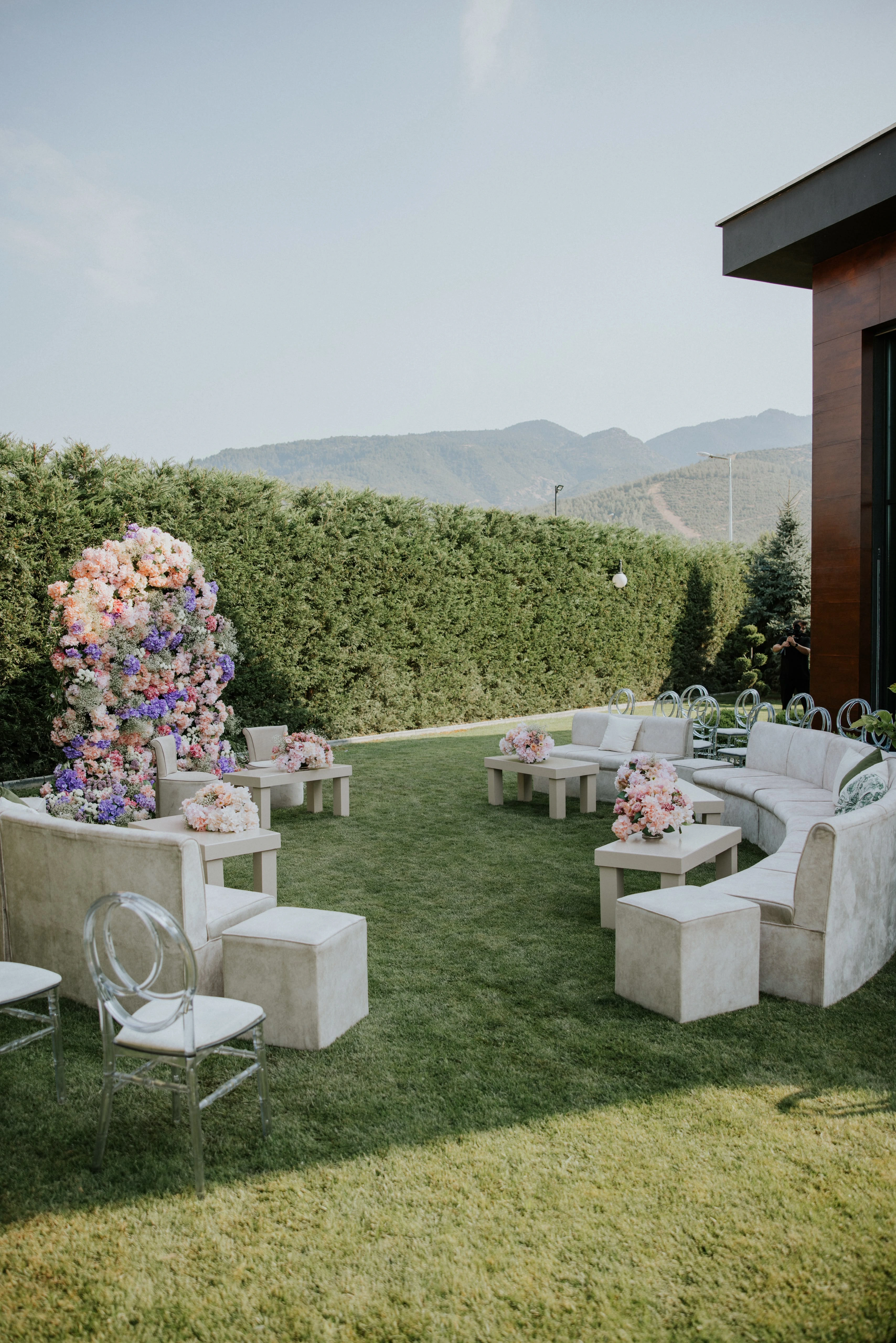Wide view of a floral tower and curved seating groups in a garden with mountain views