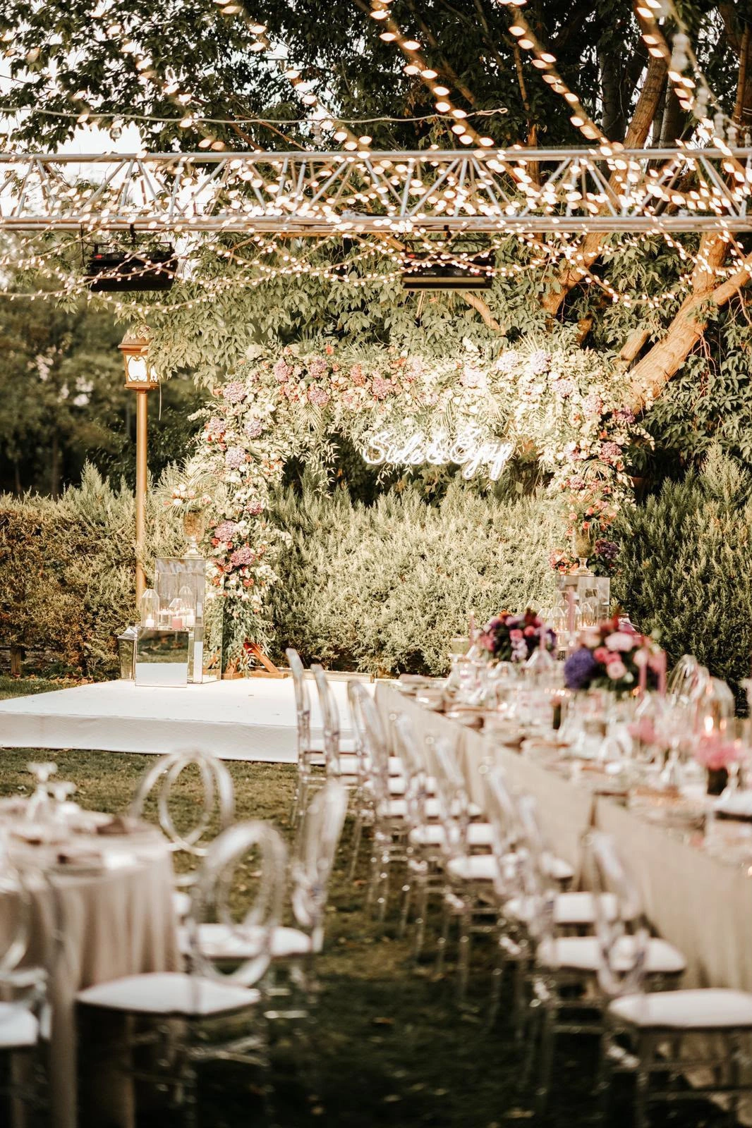 Engagement table beneath string lights and chandeliers